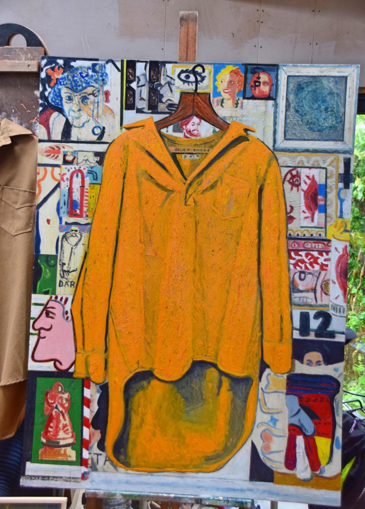 Painting on an easel featuring a large yellow shirt on a hanger, surrounded by smaller images including faces and abstract shapes